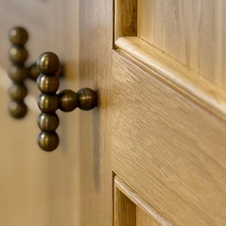 Bespoke Dressing Room Worcester Close-up of a wooden cabinet door with a decorative metal handle.